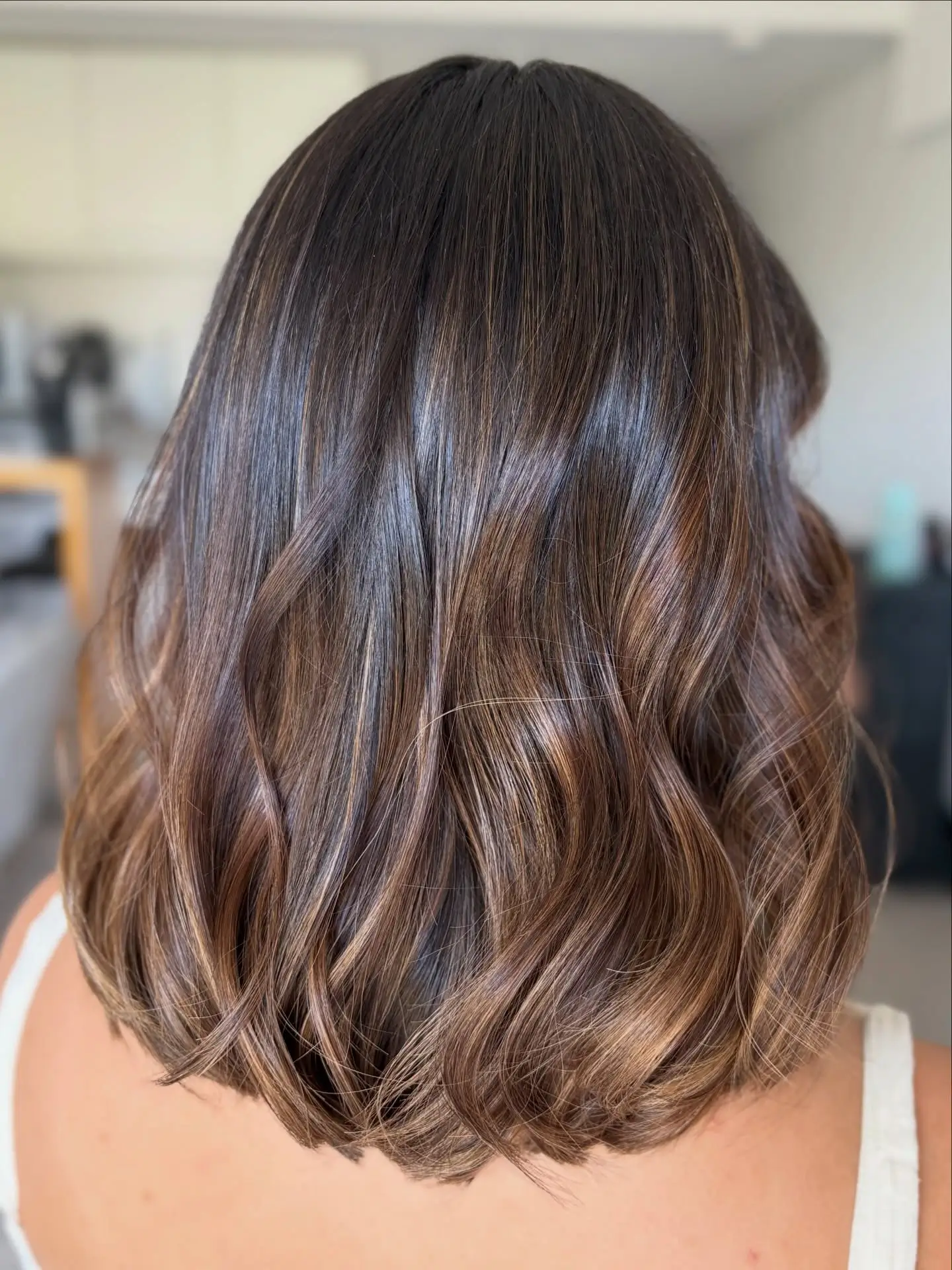 summer hair color ideas 2026 Glossy Cocoa Waves With Barely-There Highlights
