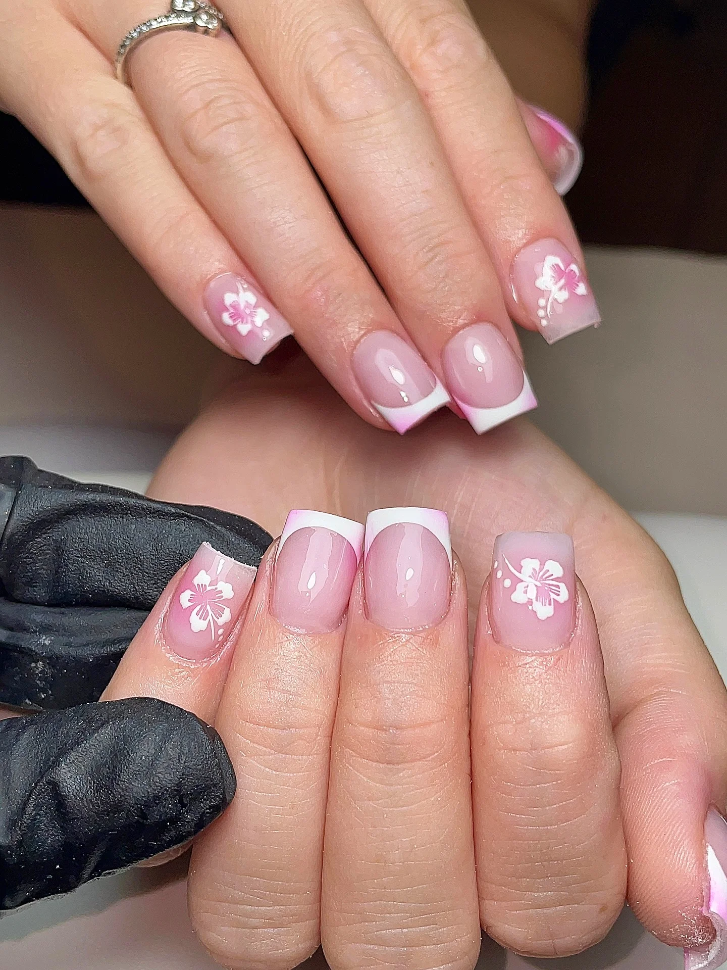 light summer nails 2026 Glossy Pink French Tips With Soft Hibiscus Art