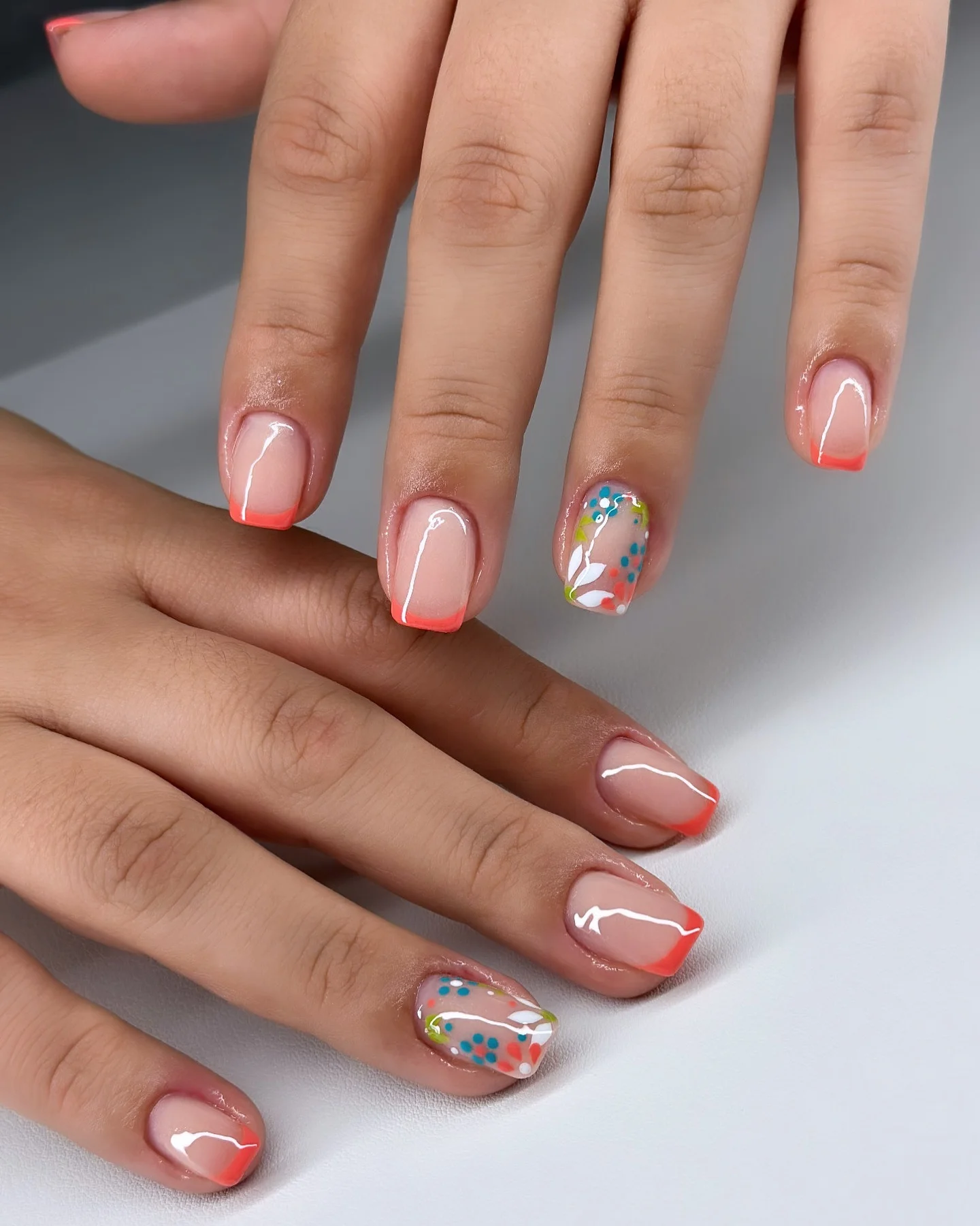 short squoval nails design 2026 Coral French Tips With Playful Floral Accents