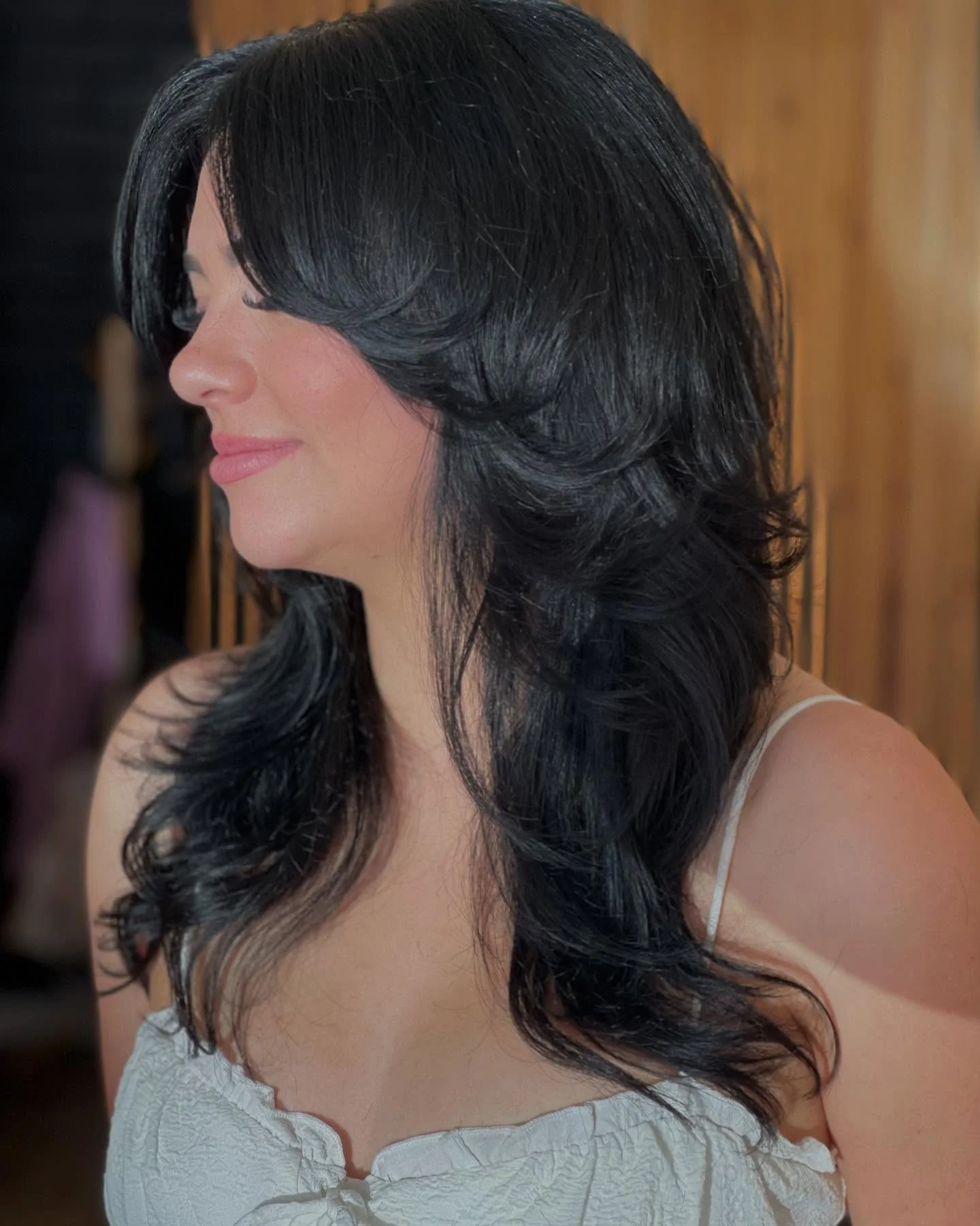 sophisticated summer haircuts for women over 40 2026 Glossy Layered Black Hair With Curtain Bangs