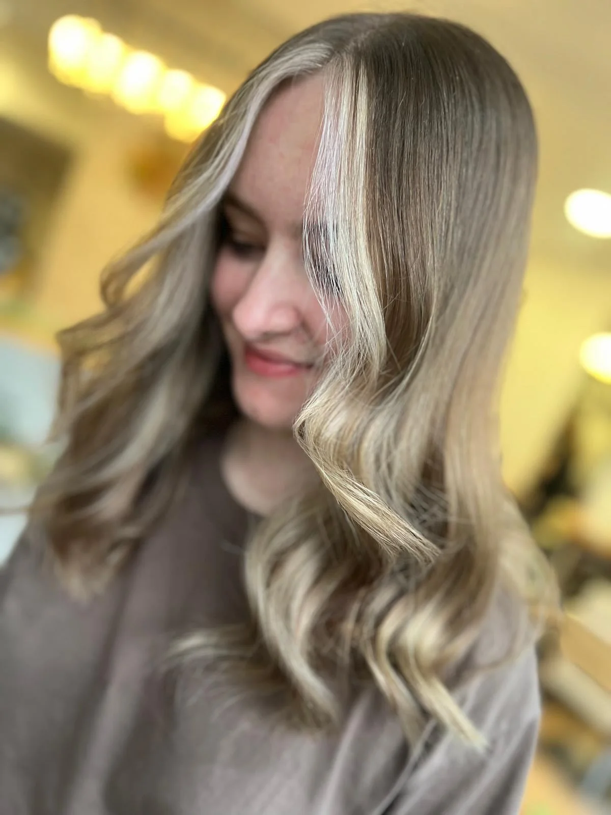 platinum summer money piece hair color 2026 Glossy Cream Blonde Money Piece With Soft Summer Waves