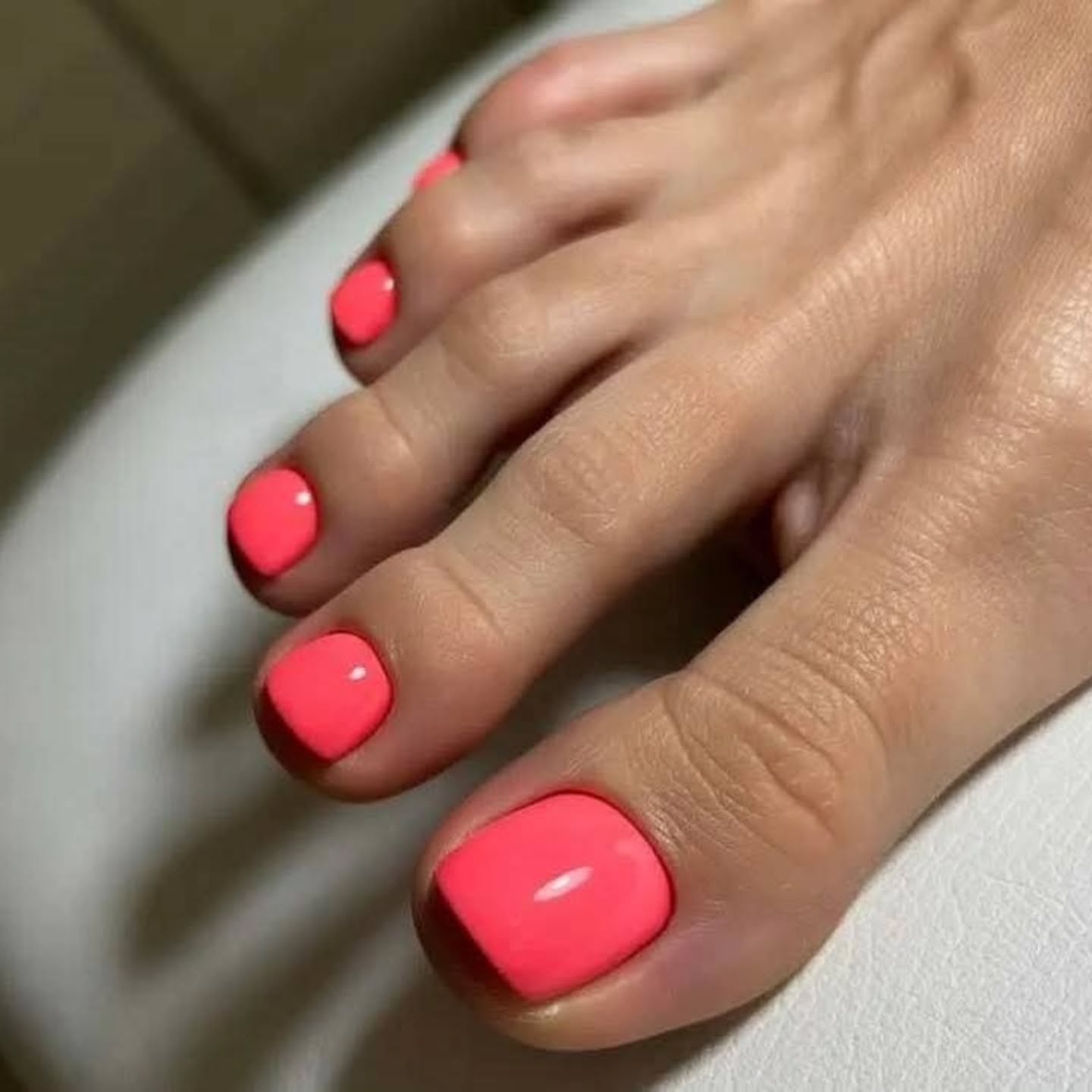 summer toe nails colors 2026 Glossy Neon Coral For The Ultimate Vacation Pedicure